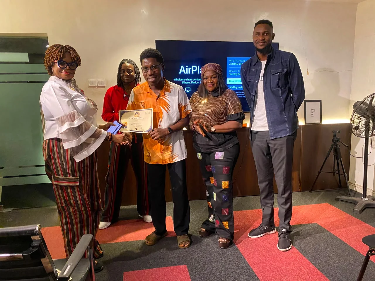 Faculty members celebrating a filmmaker receiving a certificate