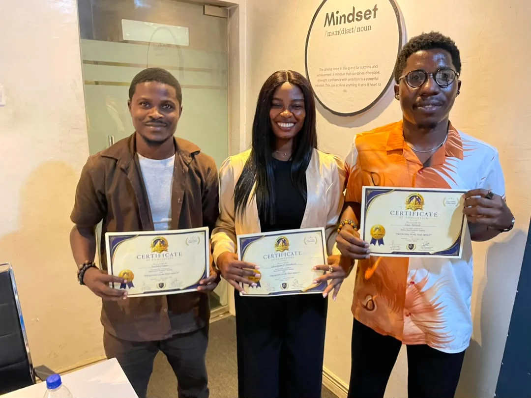 Three filmmakers proudly displaying their certificates